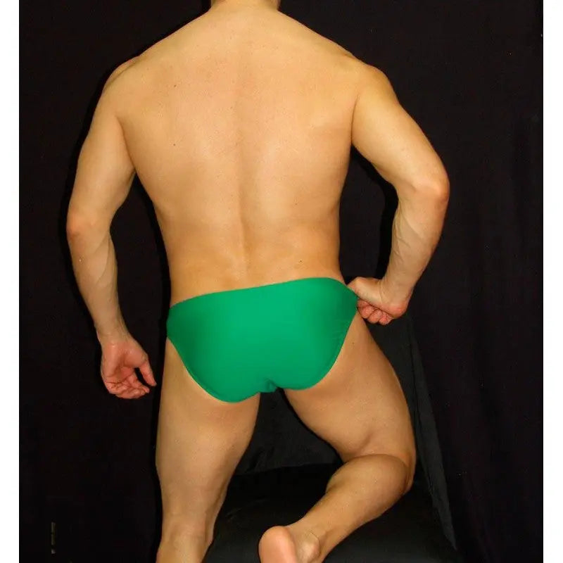 Men's green bikini swimsuit by Arroyman featuring a snug fit and smooth fabric shown from the back.