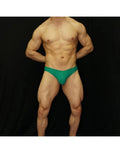 Green bikini swimsuit by Arroyman featuring a snug fit and minimal coverage shown on a model against a black background.