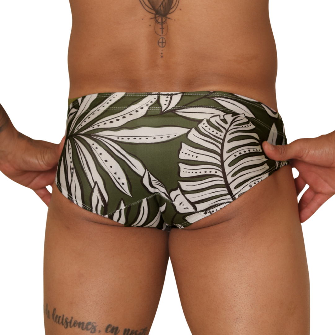 Back view of Gigo Prisma green swim brief in leaf-patterned fabric worn by a man.