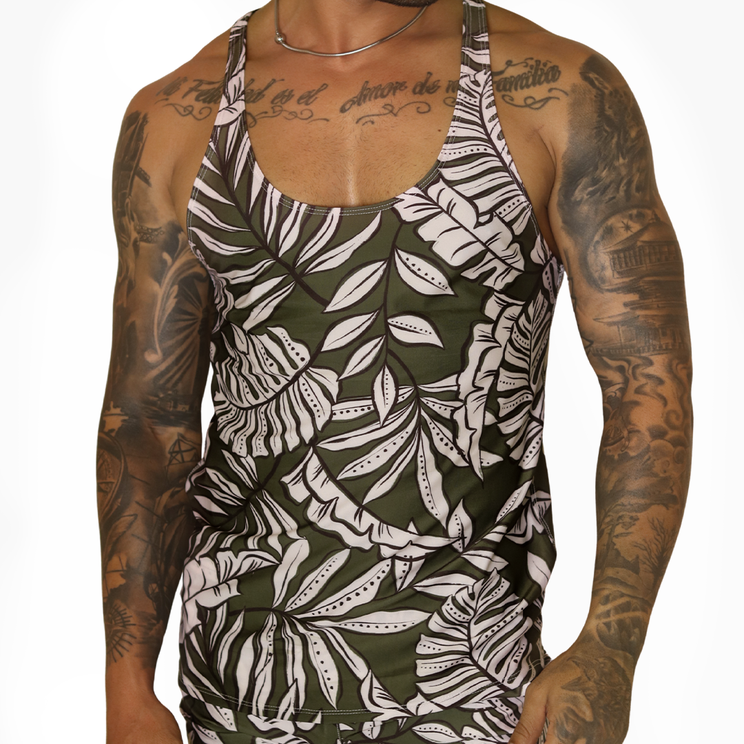 Gigo Prisma tank top in green with white leaf print. Front view of slim-fit fabric on tattooed model.