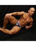 Men's bikini swimwear in navy with colorful sea flag print shown on a model by Arroyman.