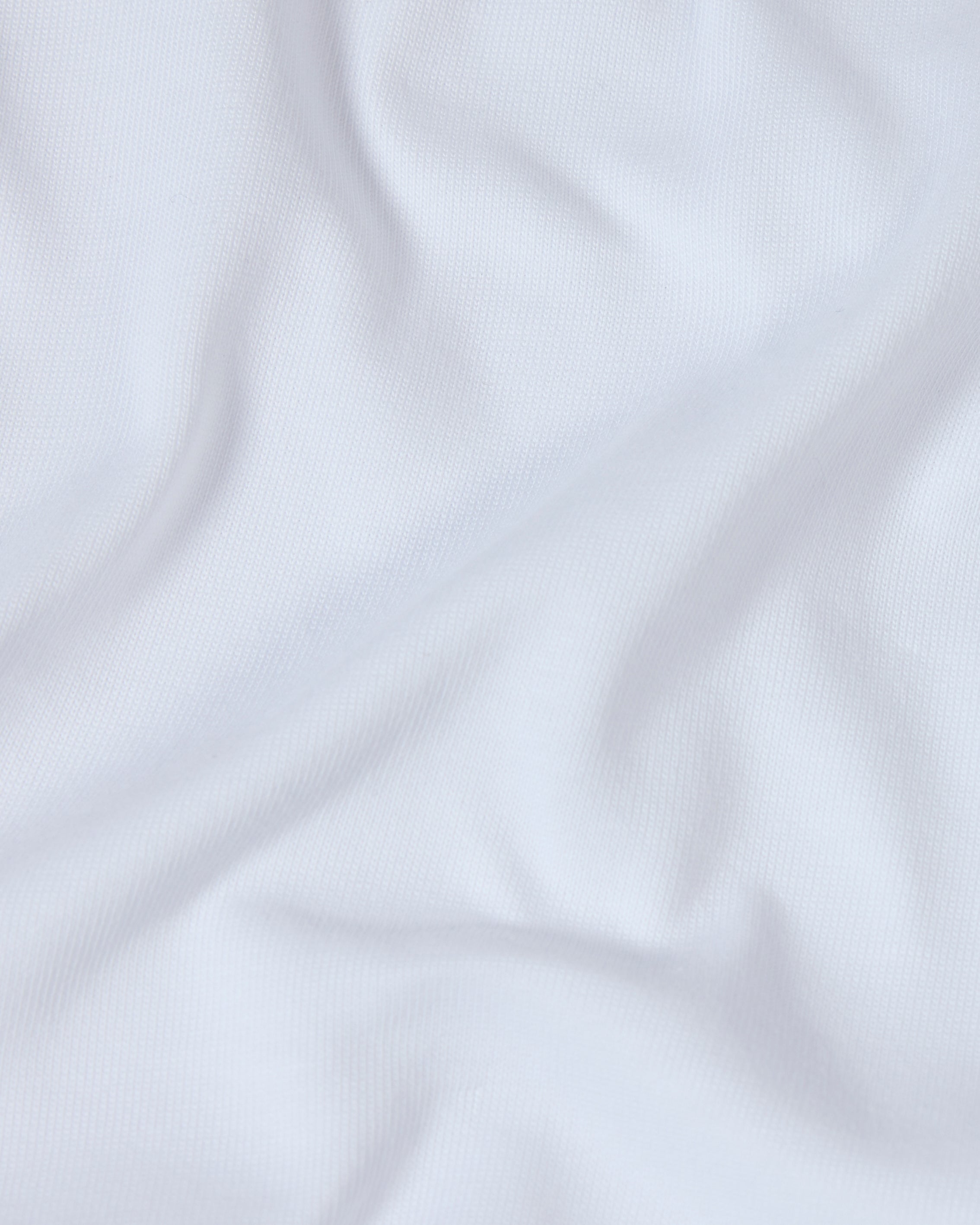 Close-up of a soft, white premium cotton fabric with gentle folds, showing a fine-knit texture.