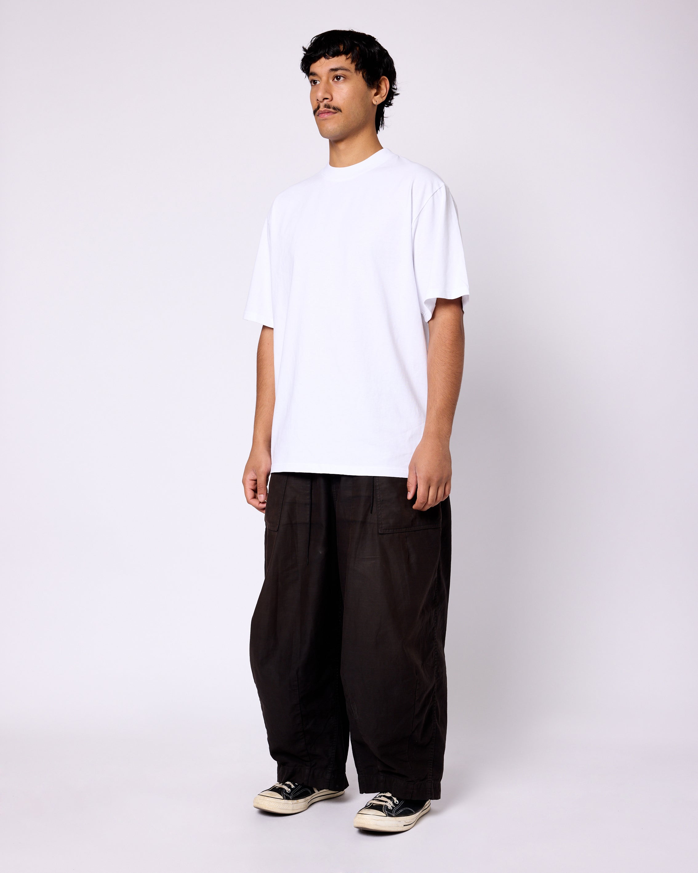 Model wearing a classic white crewneck short-sleeve tee with a clean, boxy fit against a white background.