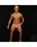 Men's pink neon thong underwear by Arroyman featuring a minimal design with a white waistband worn by a model.