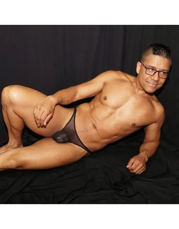 Black mesh tanga thong underwear by Arroyman featuring a sheer design and minimal coverage modeled on a man.