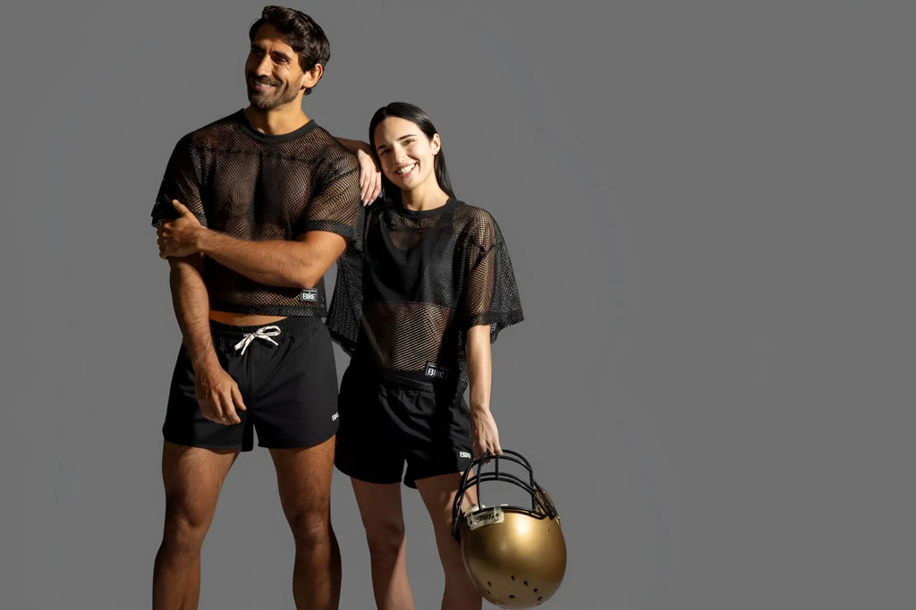 Lifestyle shot of a man and woman wearing black BIKE Athletic BAM134 short sleeve practice jerseys.