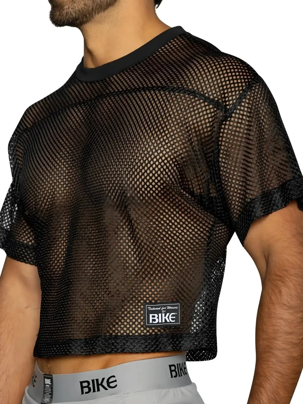 BIKE Athletic BAM134 short sleeve practice jersey in black. Side view showing mesh texture on a model.