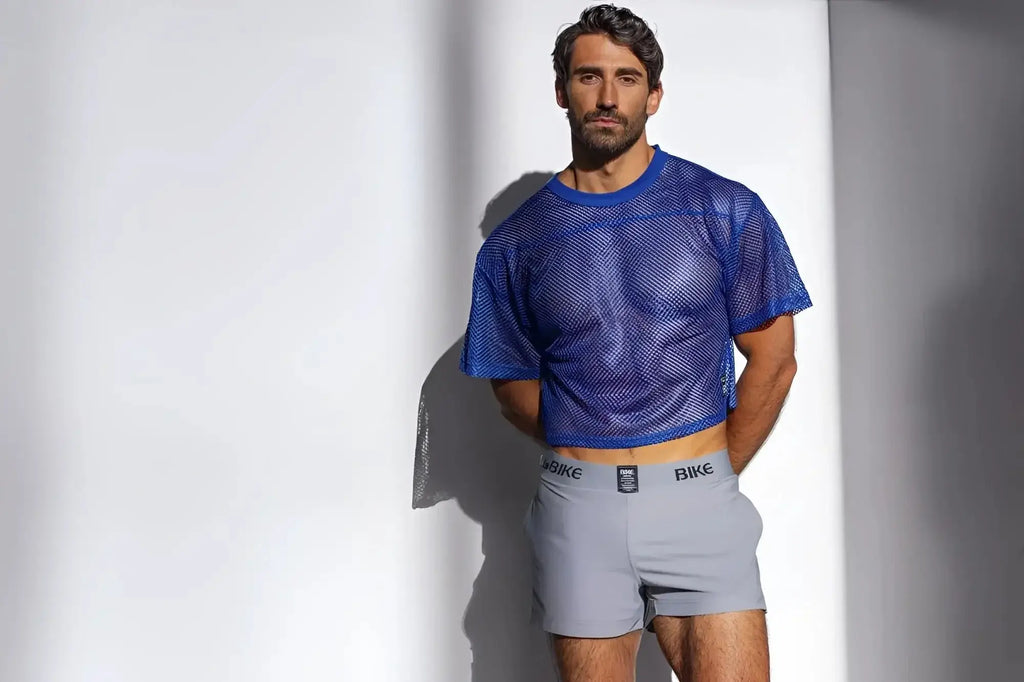 Lifestyle shot of a man wearing a royal blue BIKE Athletic BAM134 short sleeve practice mesh jersey.
