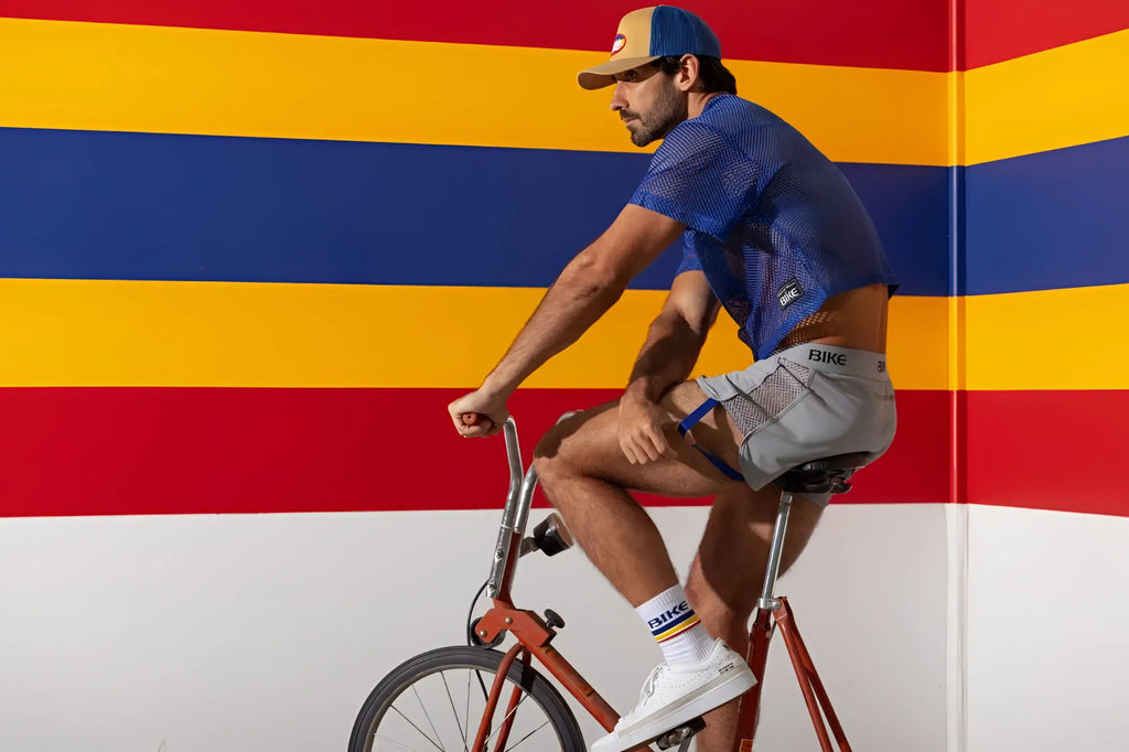 Lifestyle shot of a man wearing a royal BIKE Athletic BAM134 short sleeve practice jersey on a bicycle.