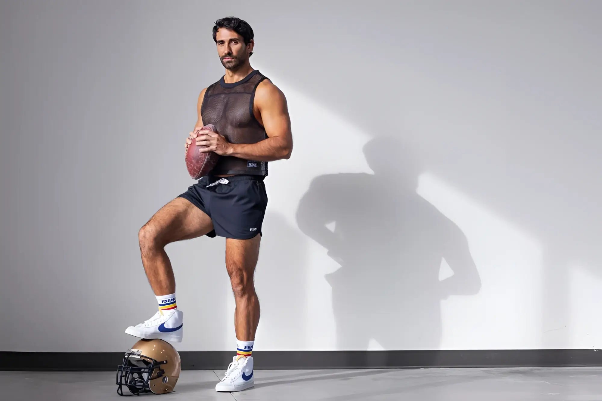 Lifestyle shot of a man wearing a black BIKE Athletic BAM135 sleeveless mesh practice jersey.
