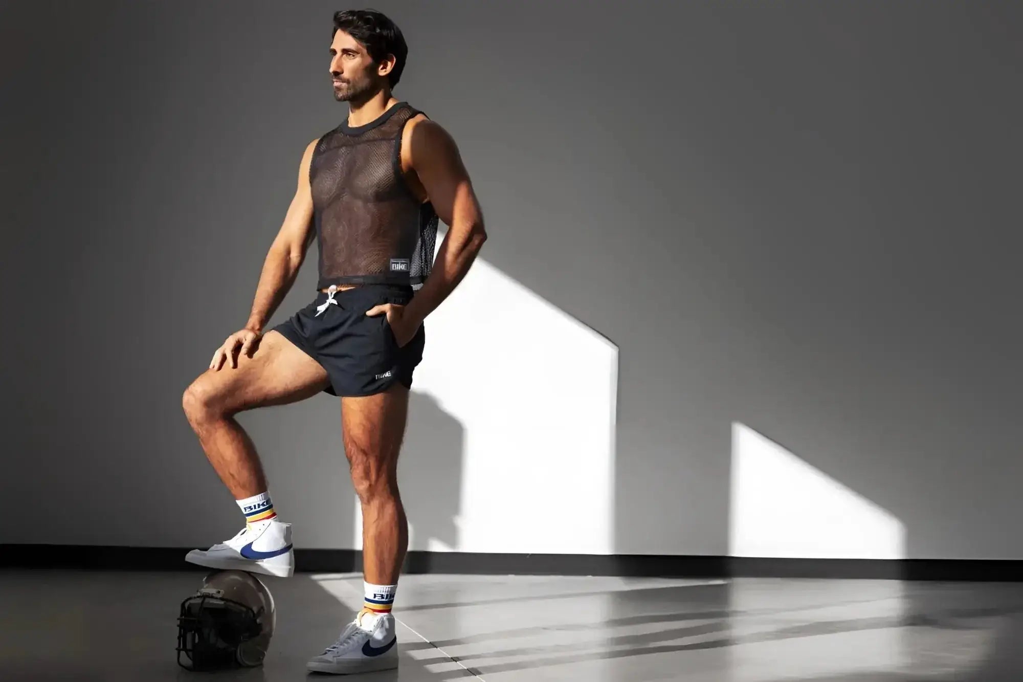 Lifestyle shot of a man wearing a black BIKE Athletic BAM135 sleeveless mesh practice jersey.