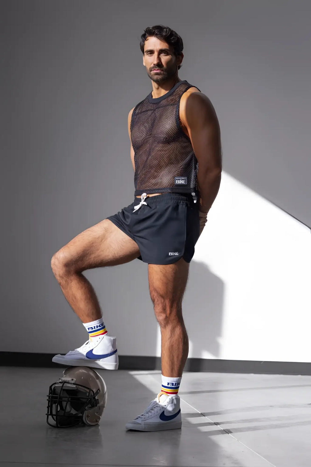 Lifestyle shot: Man wearing a black BIKE Athletic BAM135 Sleeveless Mesh Practice Jersey.