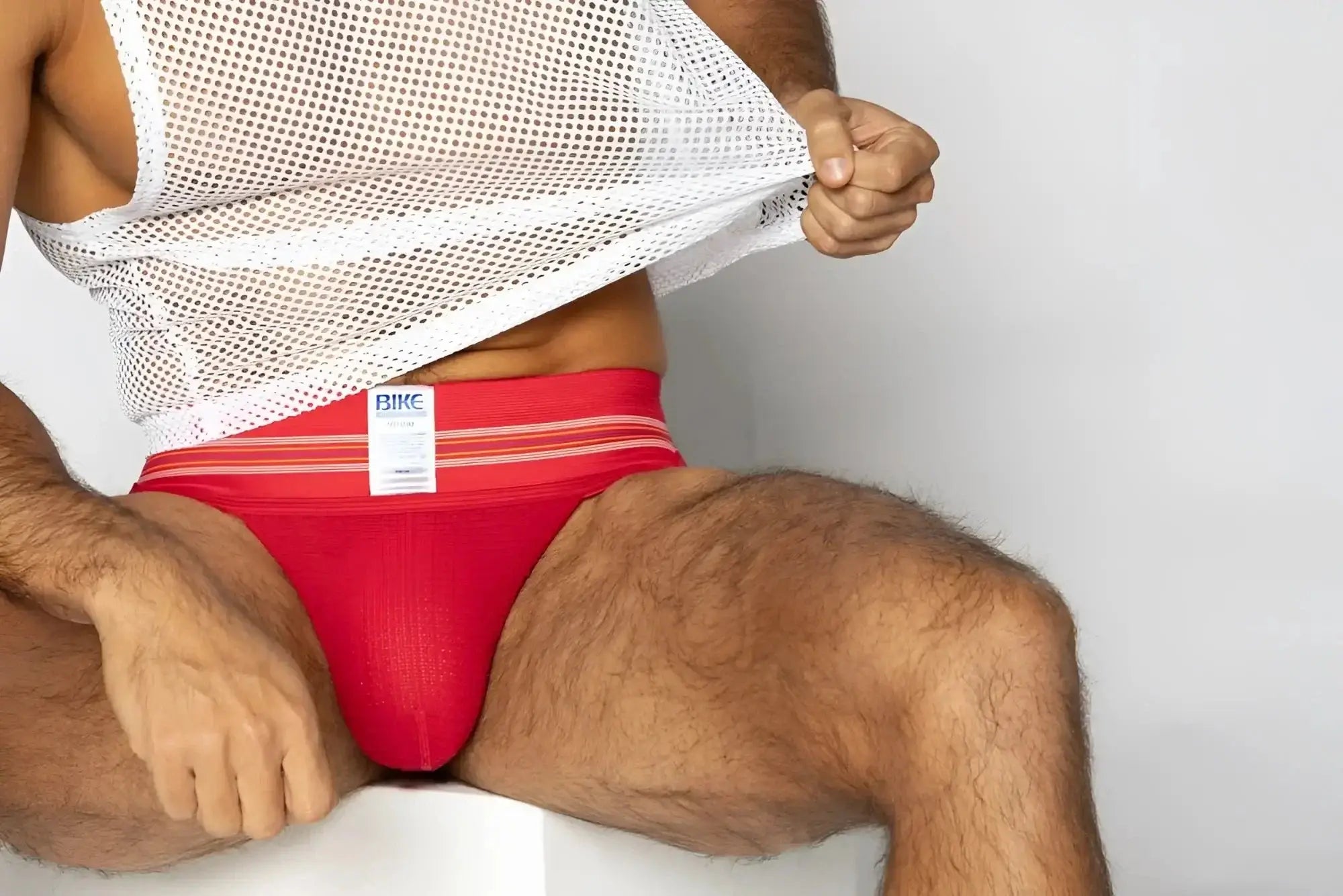 BIKE Athletic BAS306 Original Number 10 jockstrap in red. Front lifestyle view of the model wearing the underwear.