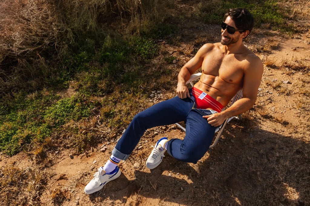 Lifestyle shot of a man wearing a red BIKE Athletic BAS306 Original Number 10 jockstrap with jeans.
