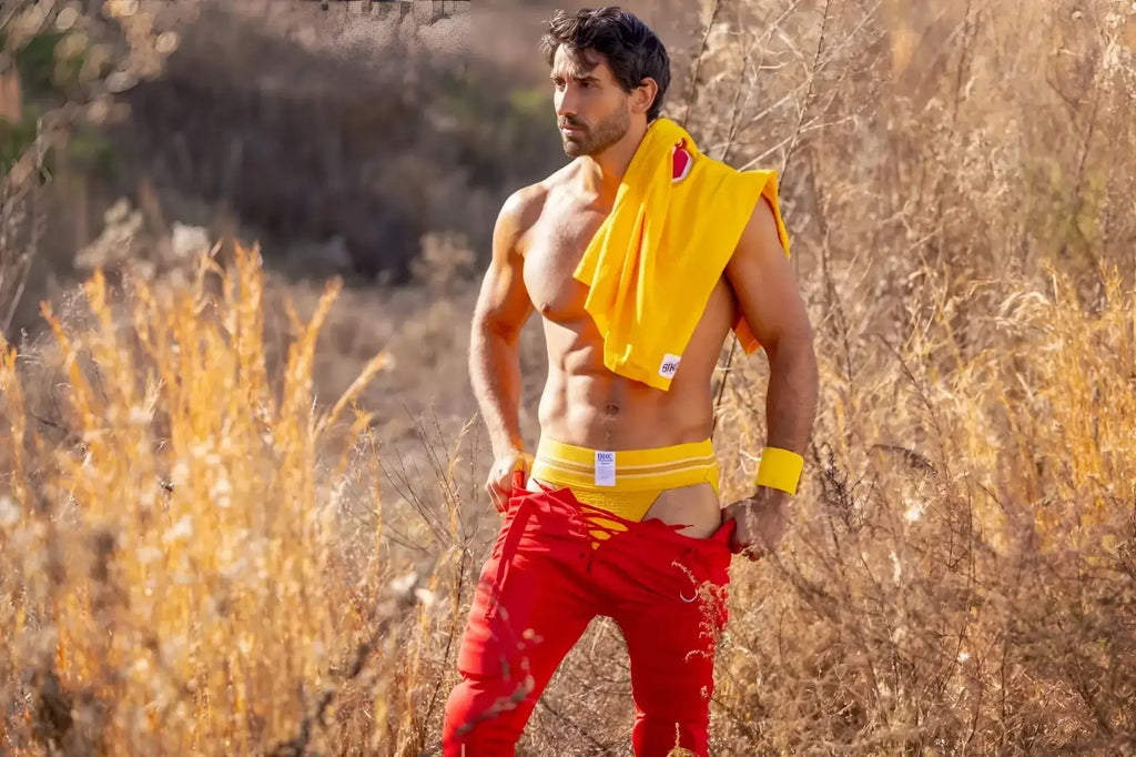 BIKE Athletic BAS306 Original Number 10 yellow jockstrap in a lifestyle shot with a model outdoors.
