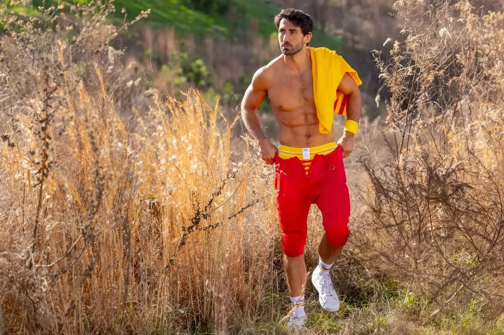 Lifestyle shot of a man wearing a yellow BIKE Athletic BAS306 Original Number 10 jockstrap under red football pants.