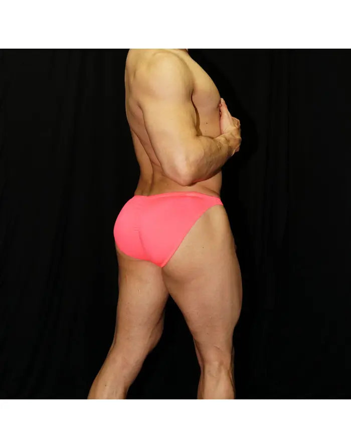 Neon pink men's bikini underwear by Arroyman featuring a snug fit and minimal coverage shown on a model from the back.