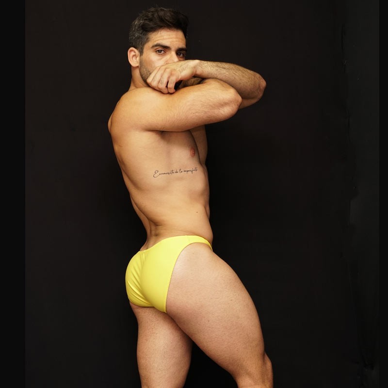 Men's yellow bikini underwear by Arroyman featuring a snug fit and smooth fabric shown on a model from the side.