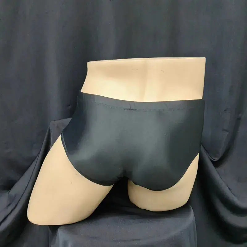 Black Brazilian sunga swimwear by Arroyman featuring a sleek design and smooth fabric shown on a mannequin.