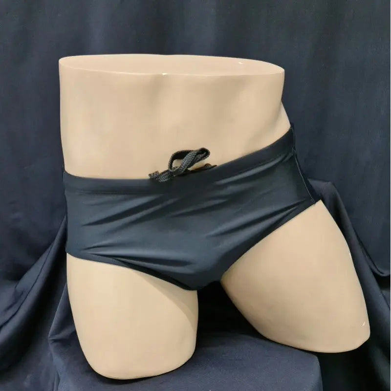 Arroyman men's black Brazilian sunga swimwear featuring a low-rise cut and drawstring waistband displayed on a mannequin.