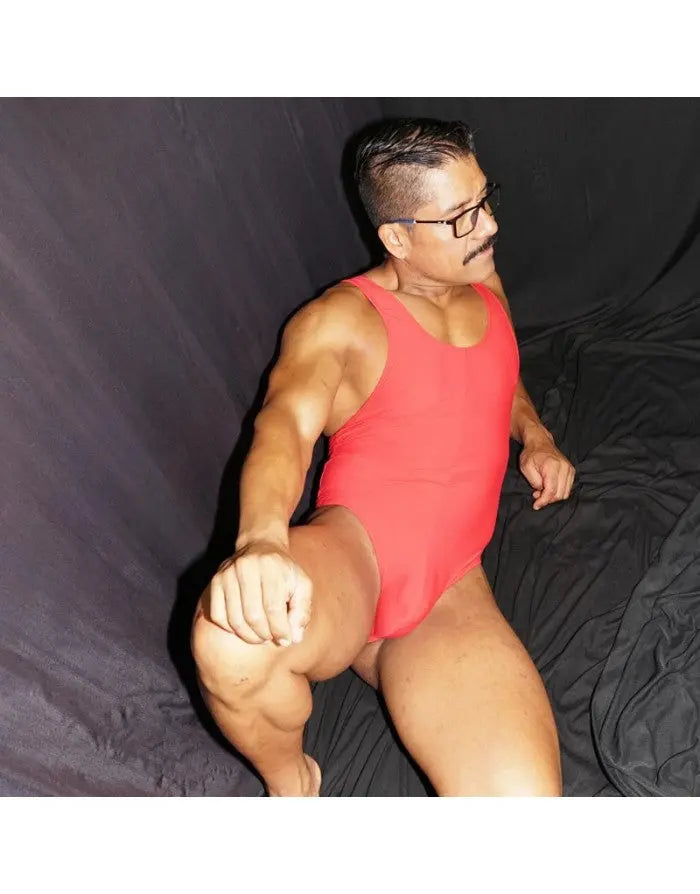 Red bodysuit thong made of stretchy material featuring a fitted design shown on a model by Arroyman.