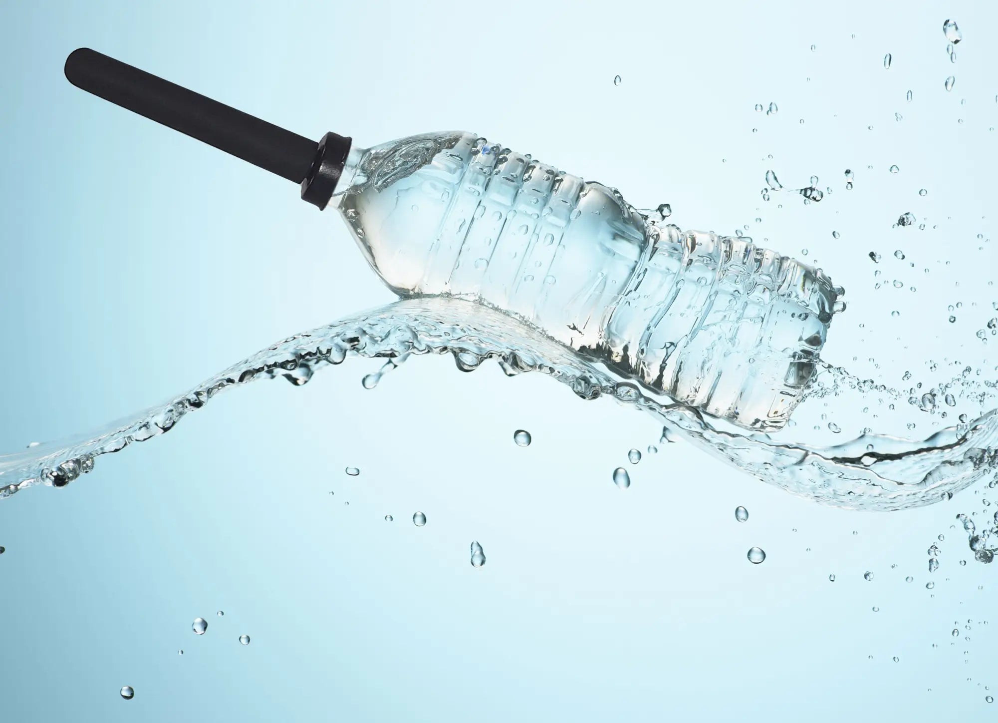 Clear plastic water bottle with black cap and ridged texture partially submerged in splashing liquid for boneyard the skwert 5 pc douche kit