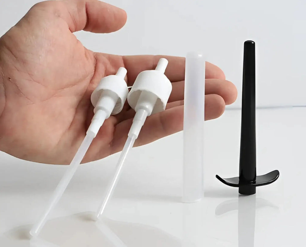 Two white plastic pump dispenser nozzles with clear tubes and one black curved plastic nozzle.