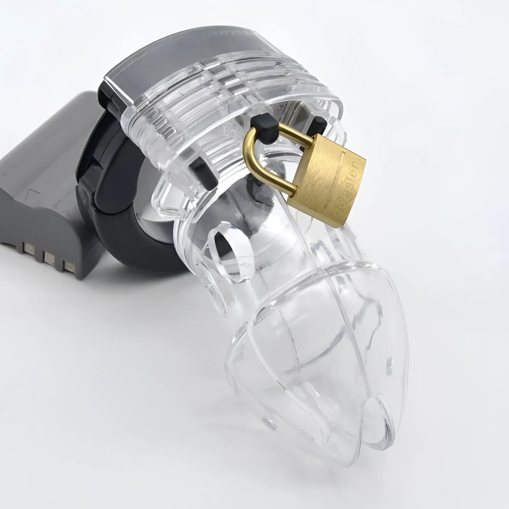 Clear plastic chastity cage brutus alpha with a gold-colored padlock secured to its top for secure wear