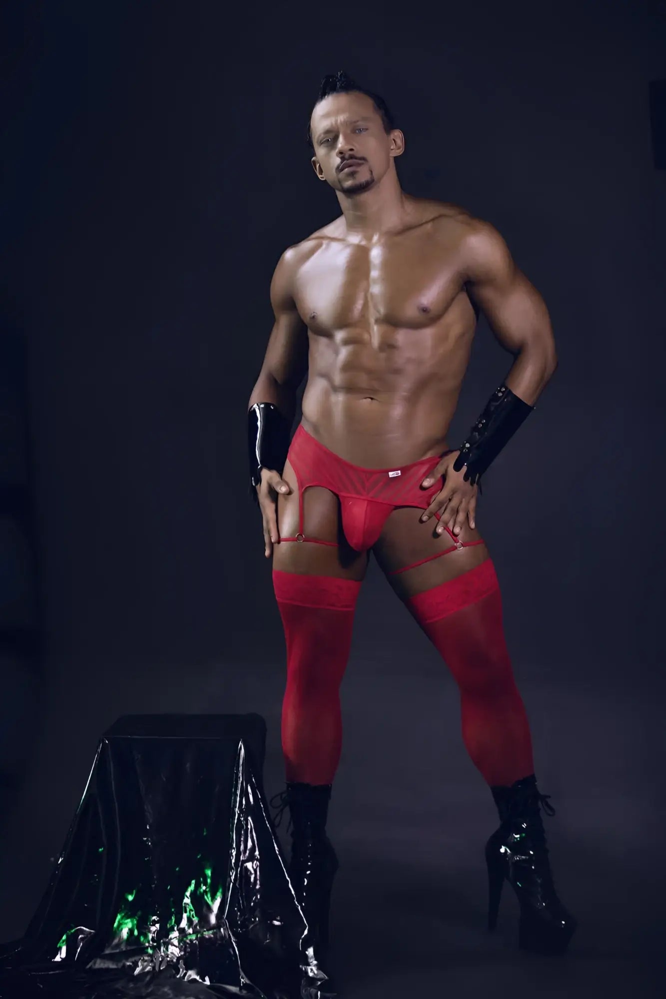 Red lace-trimmed high-waisted men’s briefs with mesh garter thongs and matching thigh-high stockings in red