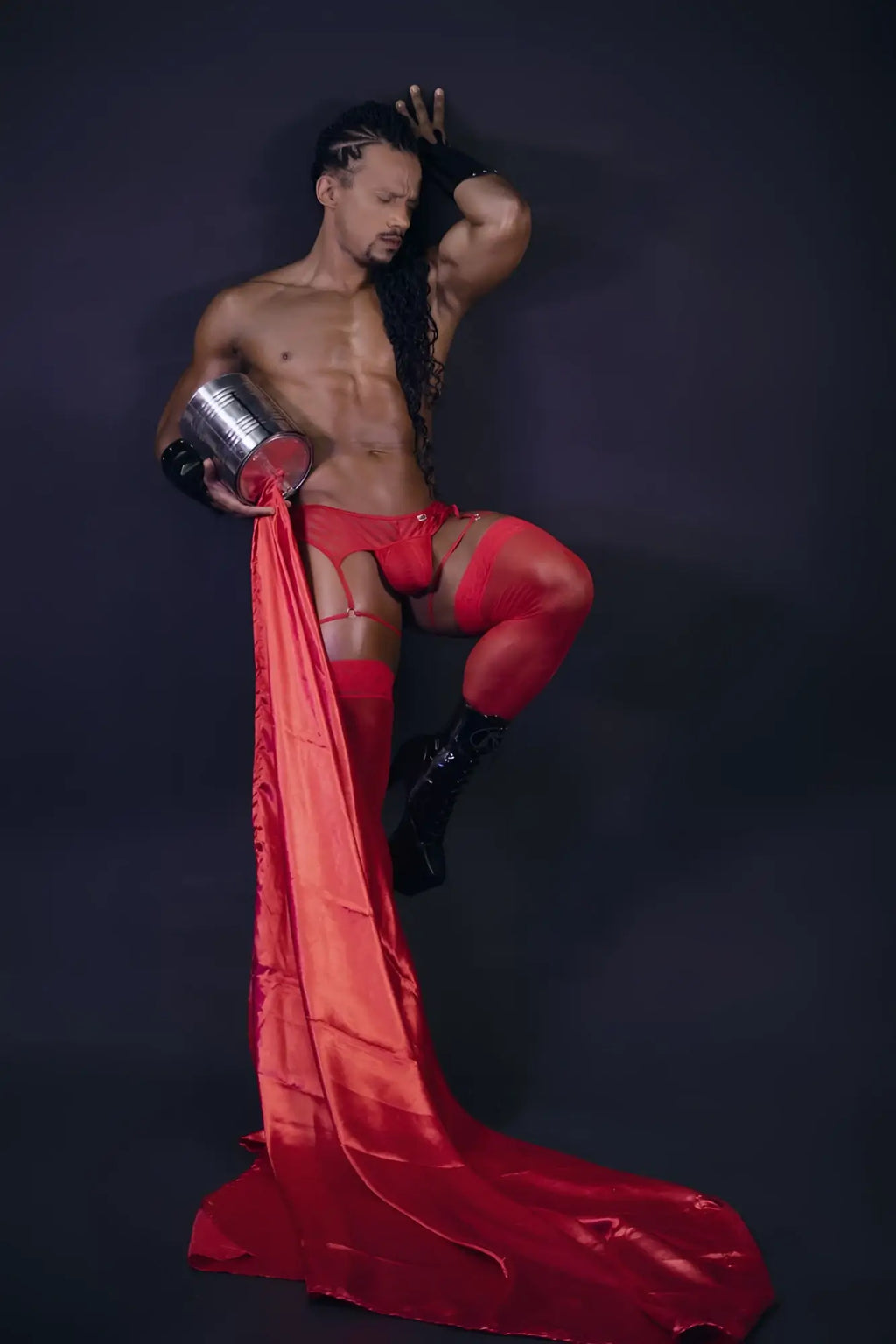 Shiny red satin fabric flowing from a mans leg wearing candyman 99792 mesh garter thongs in color red