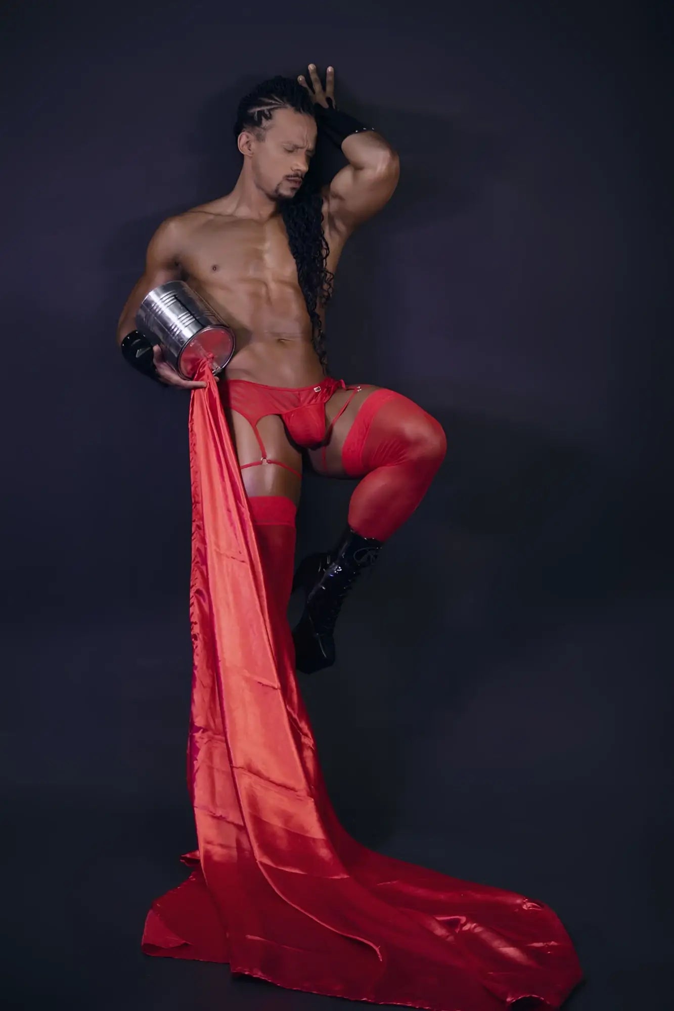 Shiny red satin fabric flowing from a mans leg wearing candyman 99792 mesh garter thongs in color red