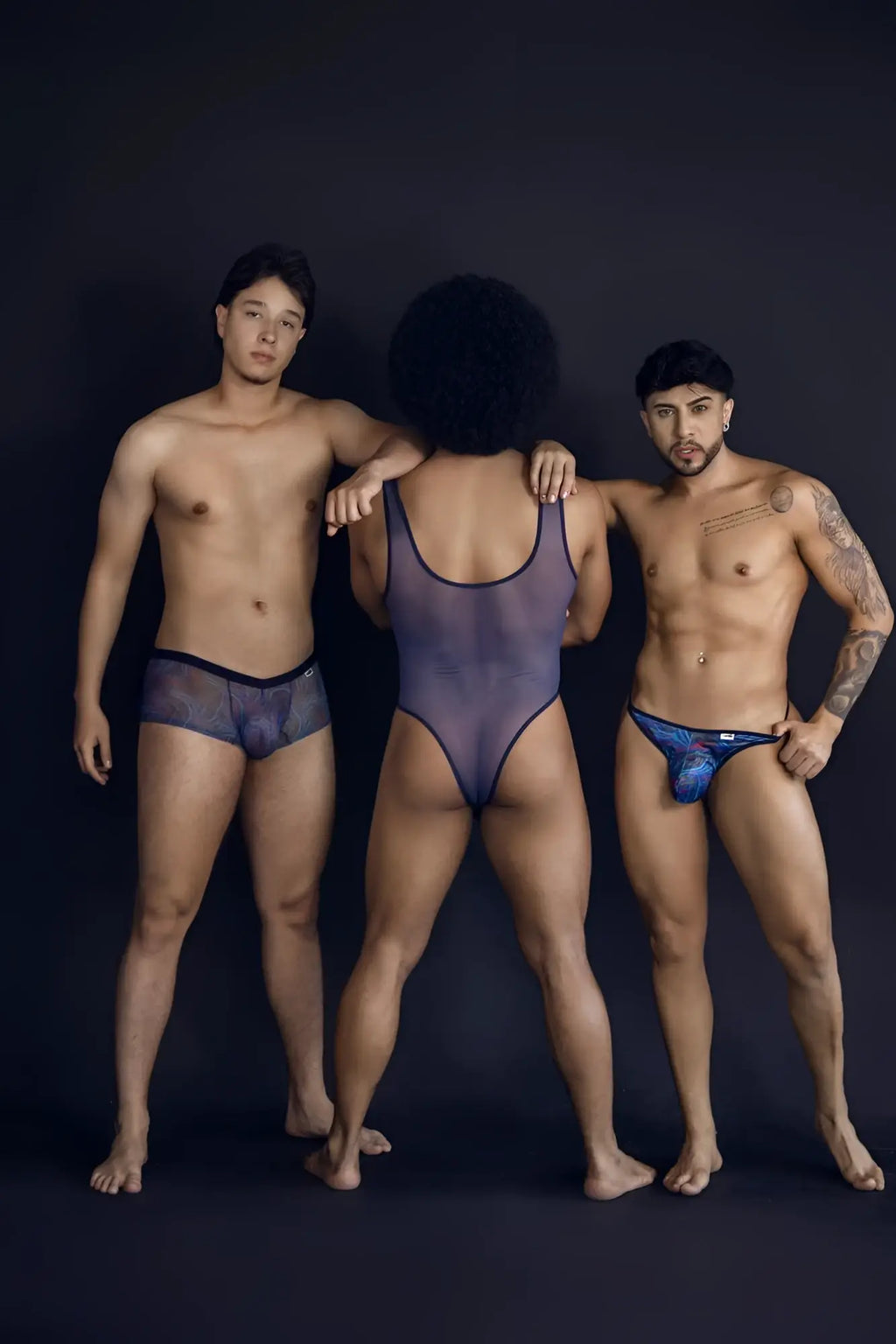 The central figure wears a sheer dark purple one-piece bodysuit with black trim in CandyMan 99873 multicolor seawater trunks