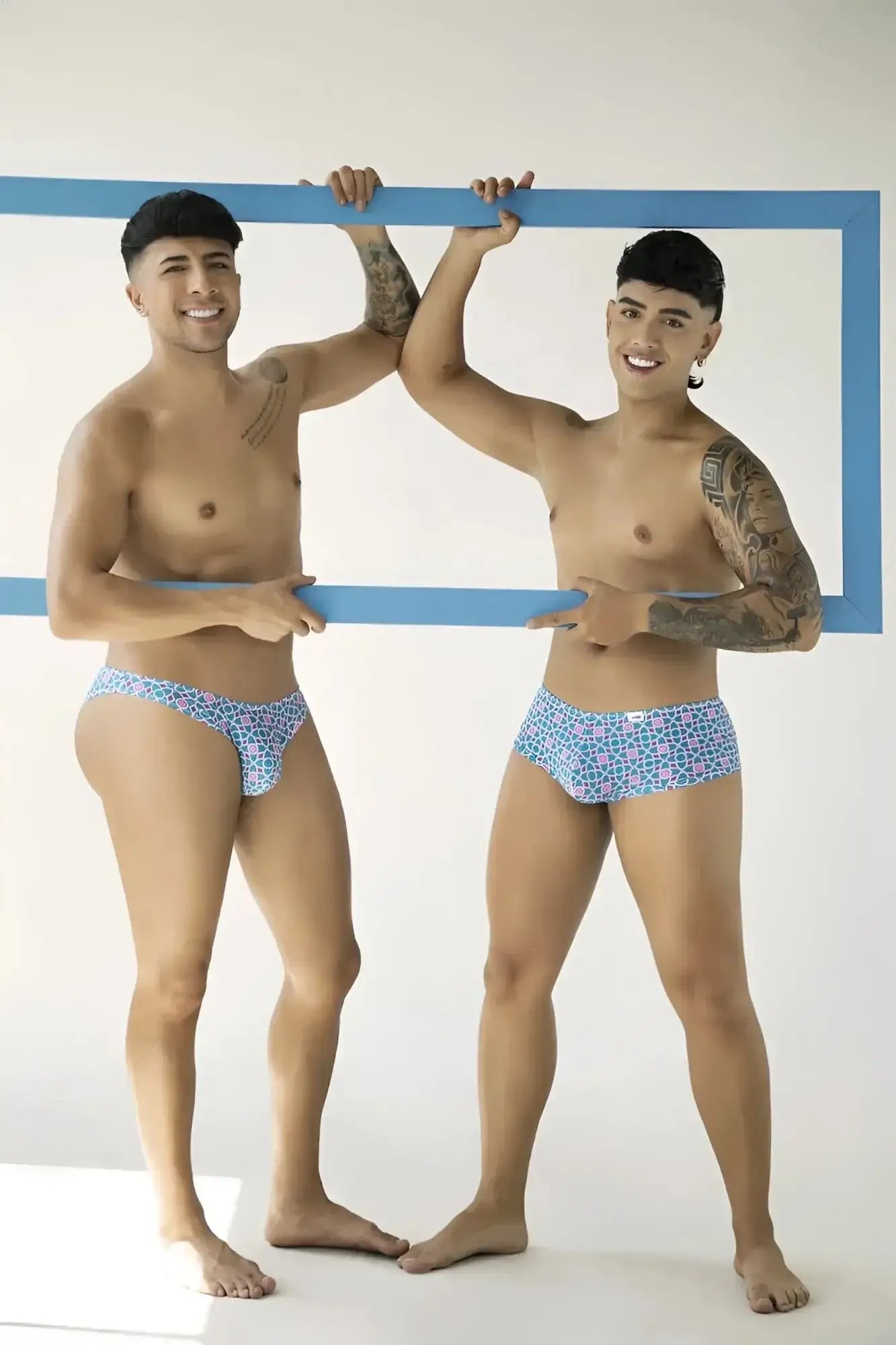 Lifestyle shot of two models wearing CandyMan 99922 printed blue trunks.