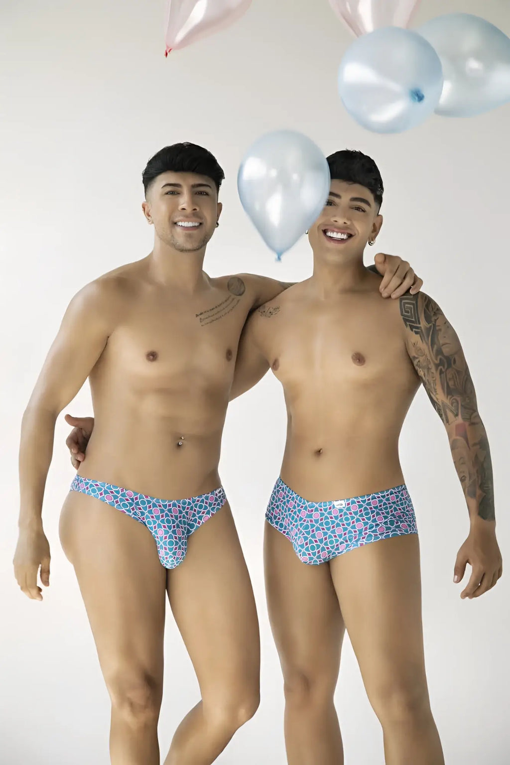 Lifestyle shot of two models wearing CandyMan 99922 printed blue trunks.
