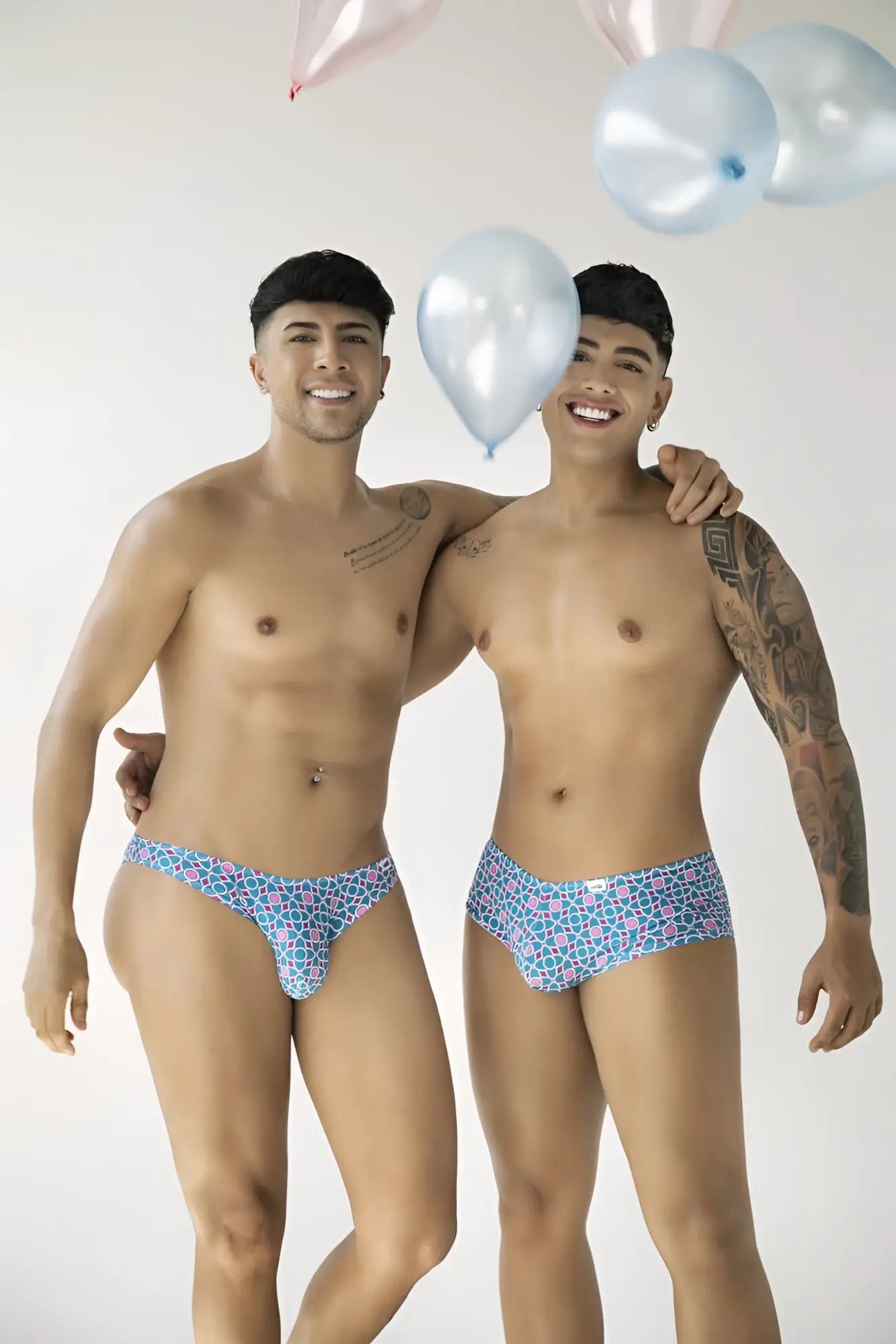 Lifestyle shot of two models wearing CandyMan 99922 printed blue trunks.