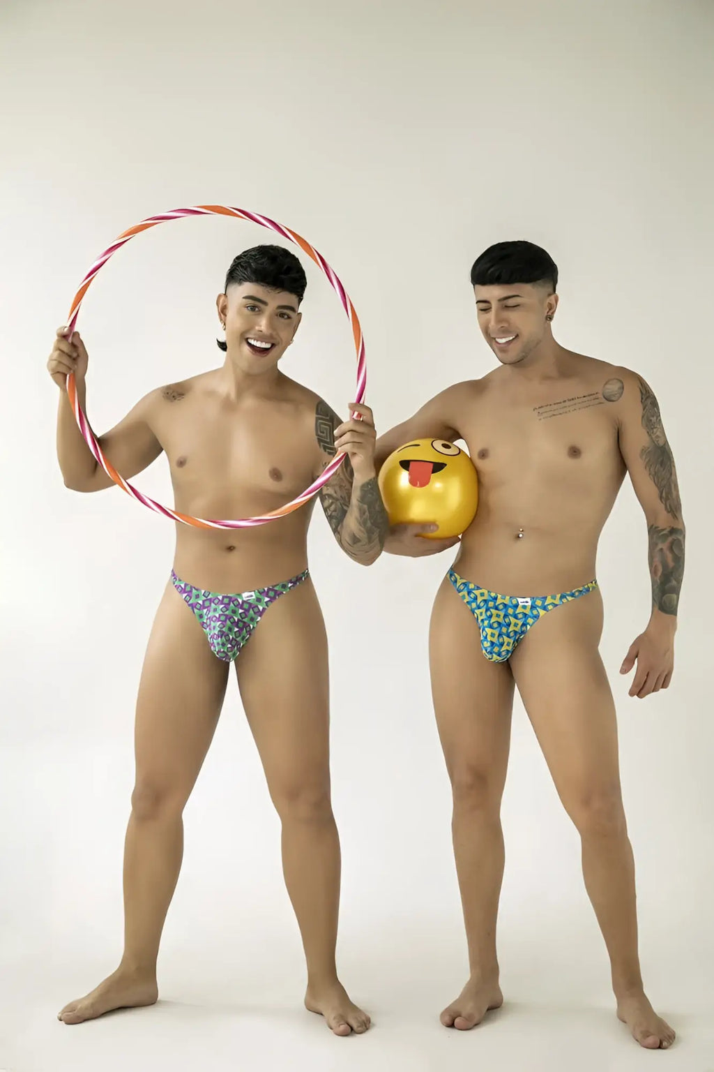 Two models wearing CandyMan 99924 turquoise printed thongs in a fun lifestyle shot with props.