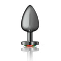 A sleek matte black metallic cheeky charms gunmetal butt plug with a smooth teardrop head and rainbow led base