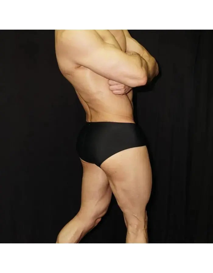 Black bodybuilding posing suit by Arroyman featuring a classic cut shown on a model from the side.
