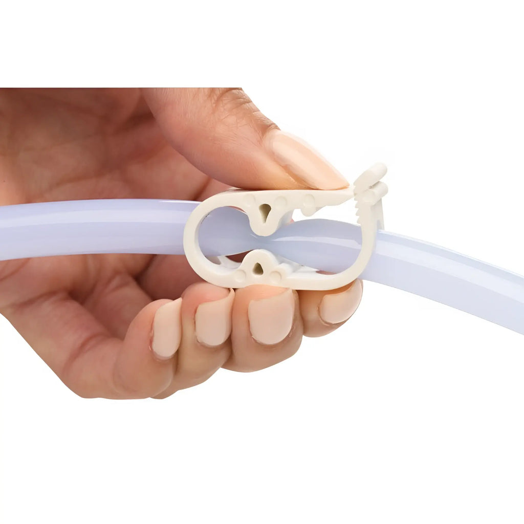 White plastic clamp gripping a translucent tube on the cleanstream deluxe shower enema bag and nozzle kit