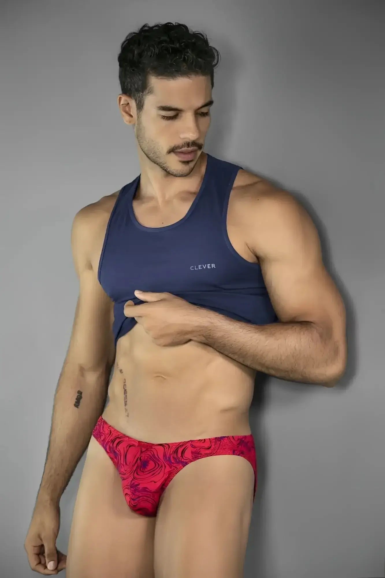 Lifestyle shot of a man wearing a red Clever 26028 Helion bikini.