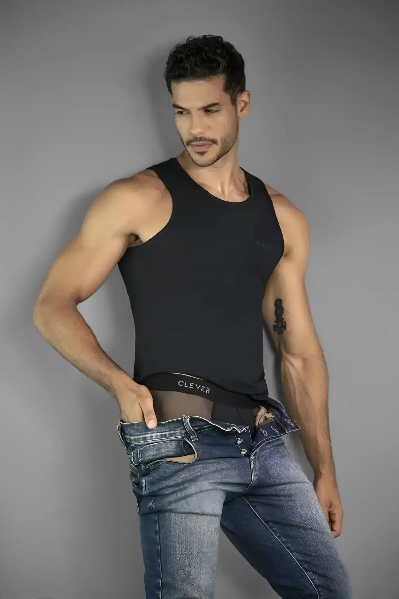 Lifestyle shot of a man wearing black Clever 26059 Tanatos briefs and matching tank top.