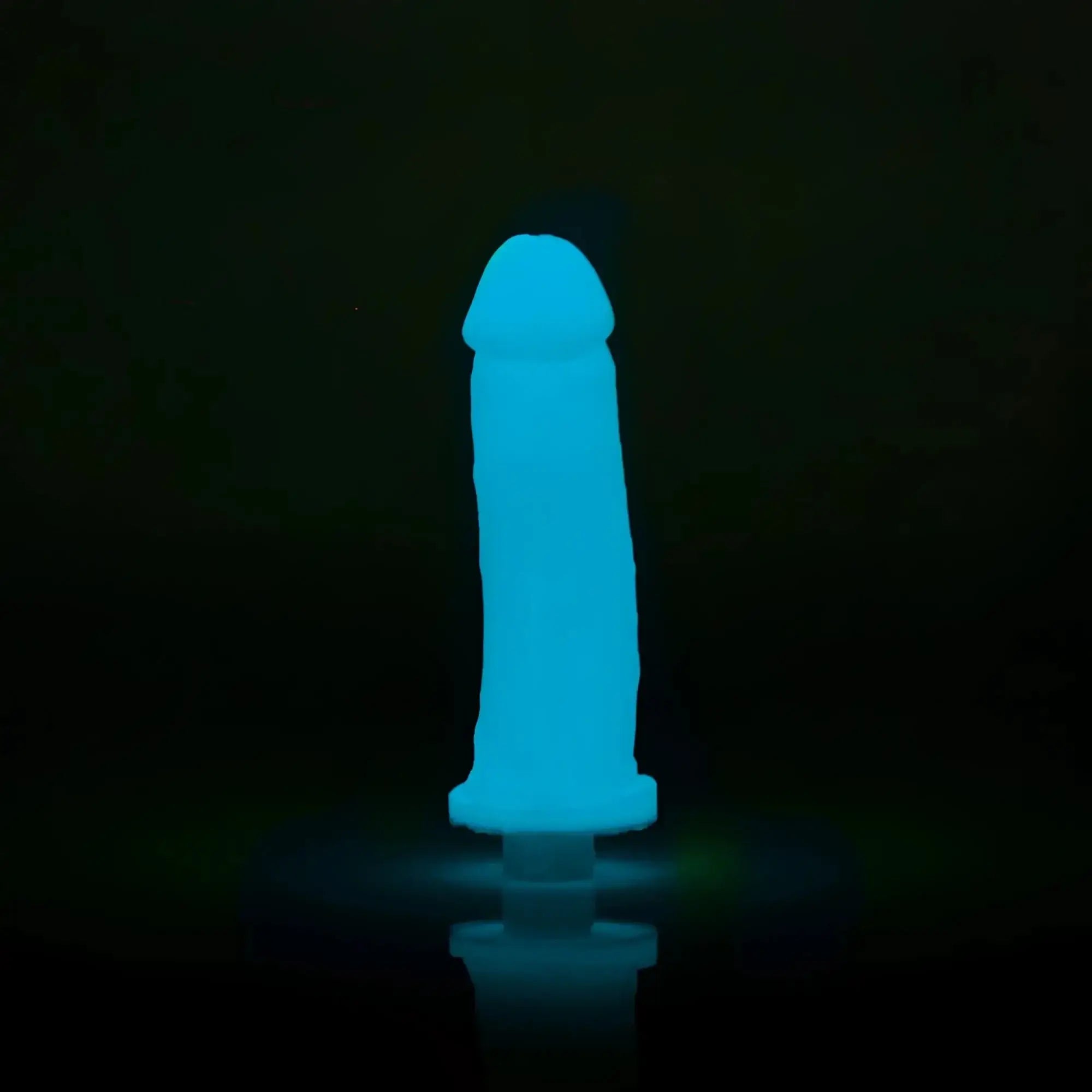 A glowing blue silicone toy clone a willy glow blue with rounded head and tapered base emitting soft light