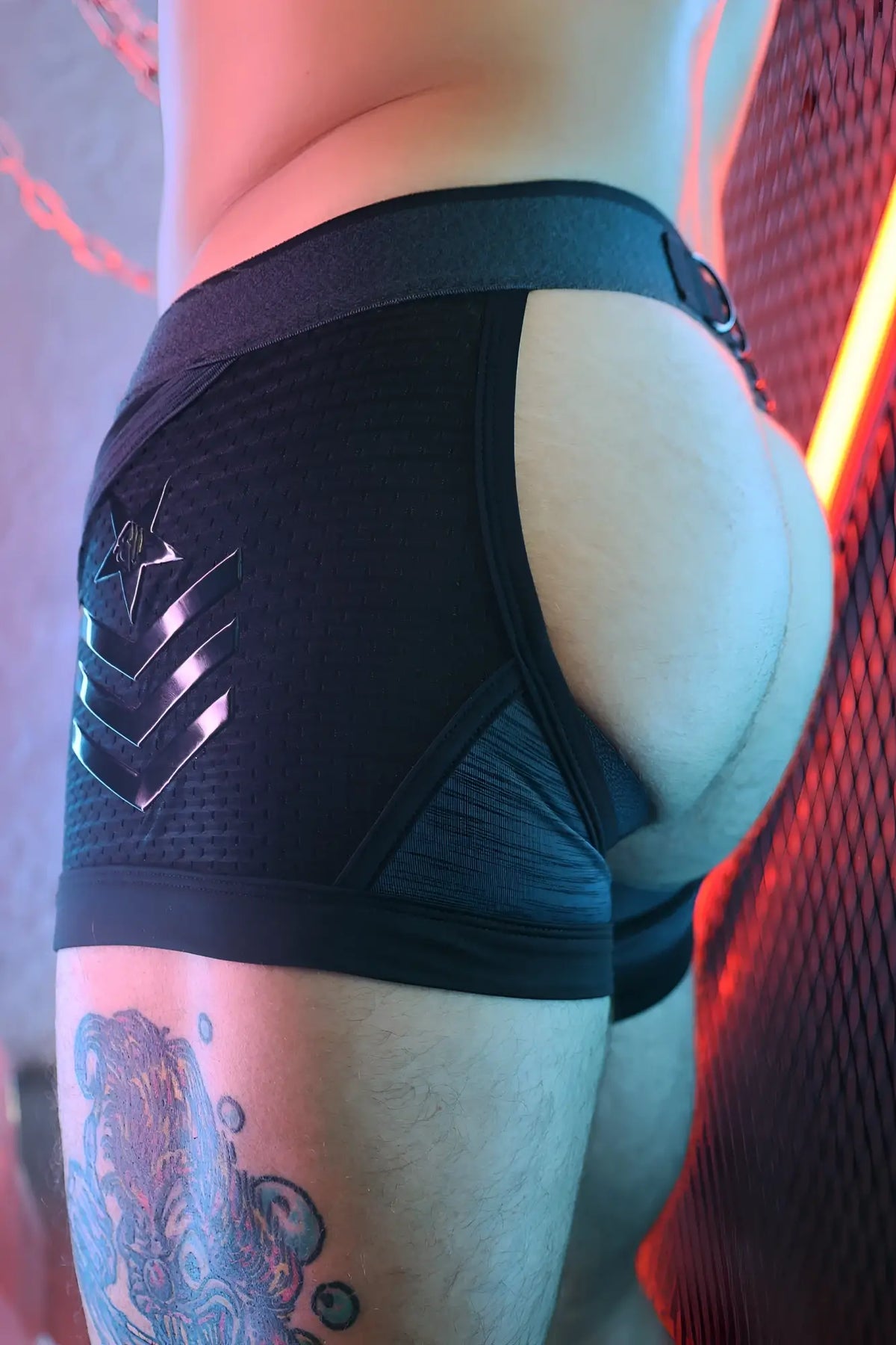 Black athletic briefs cockpit chock with metallic star and chevron emblem on the side for active wear