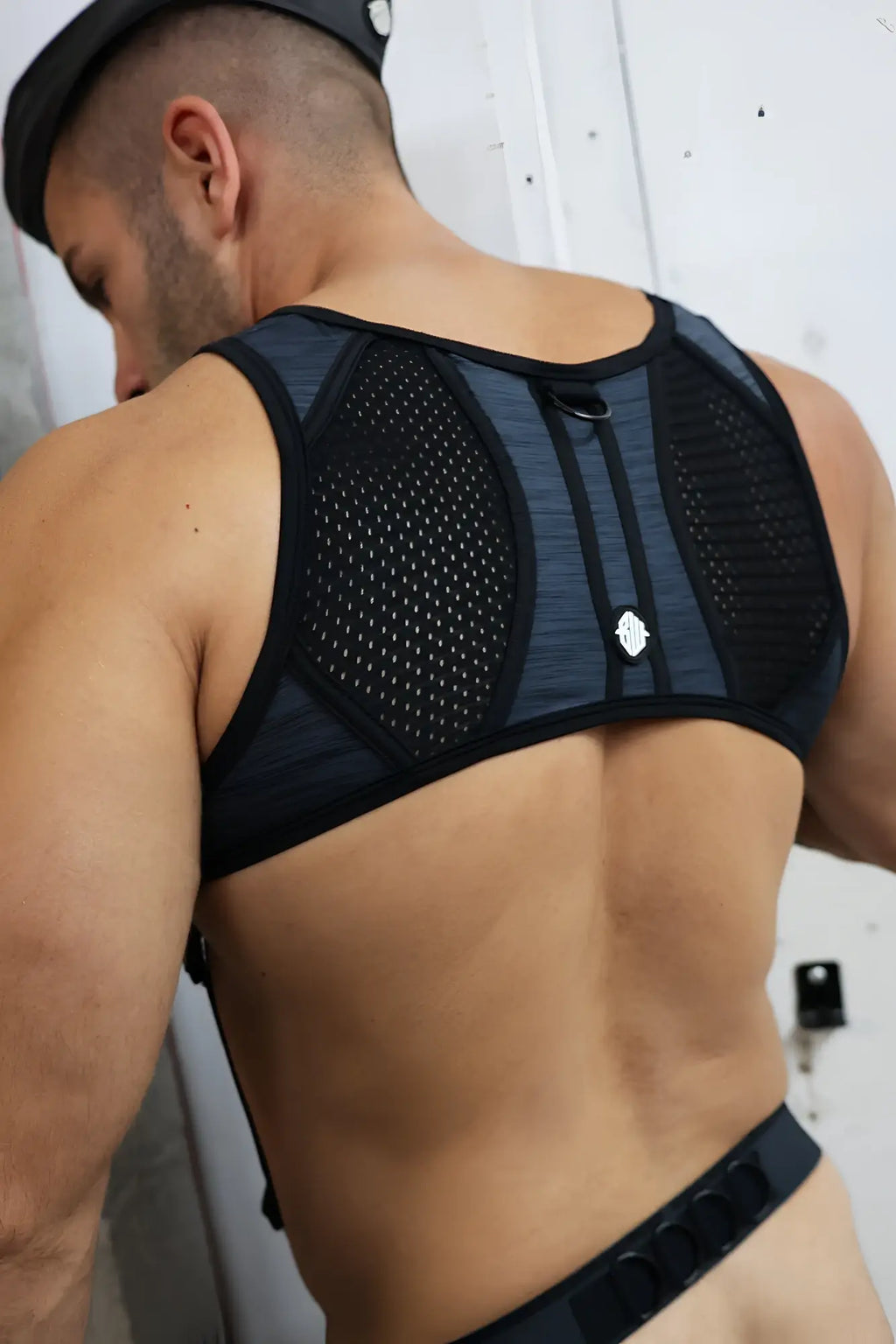 Back side of cockpit tank harness black mesh and fabric back support brace with subtle gray gradient pattern