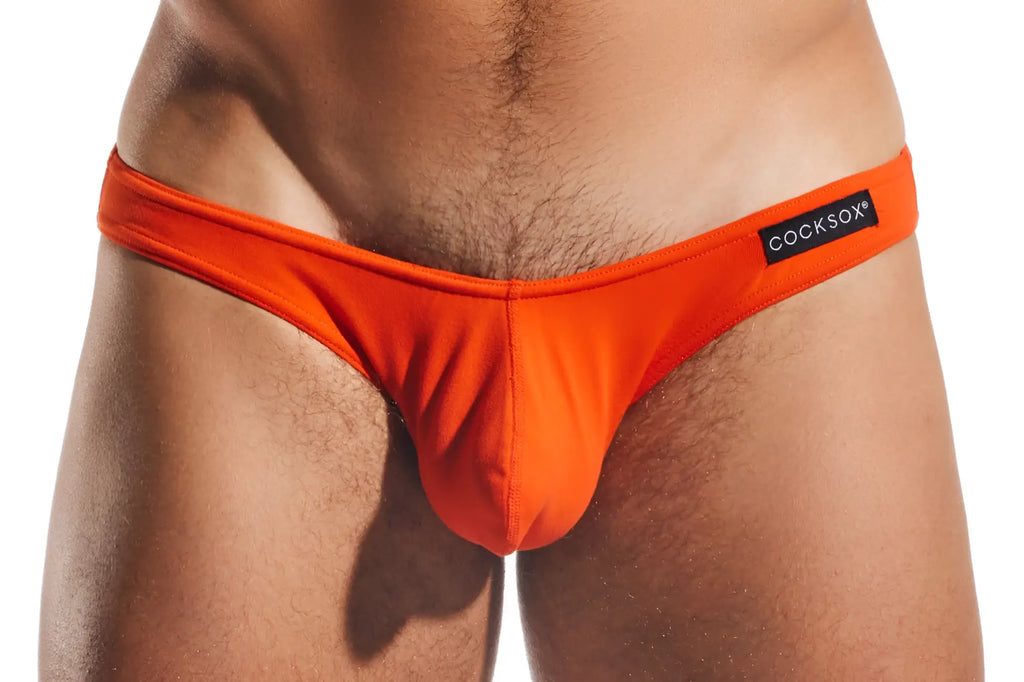Bright orange cocksox cx01 brief thong with black brand label on waistband made from comfortable material