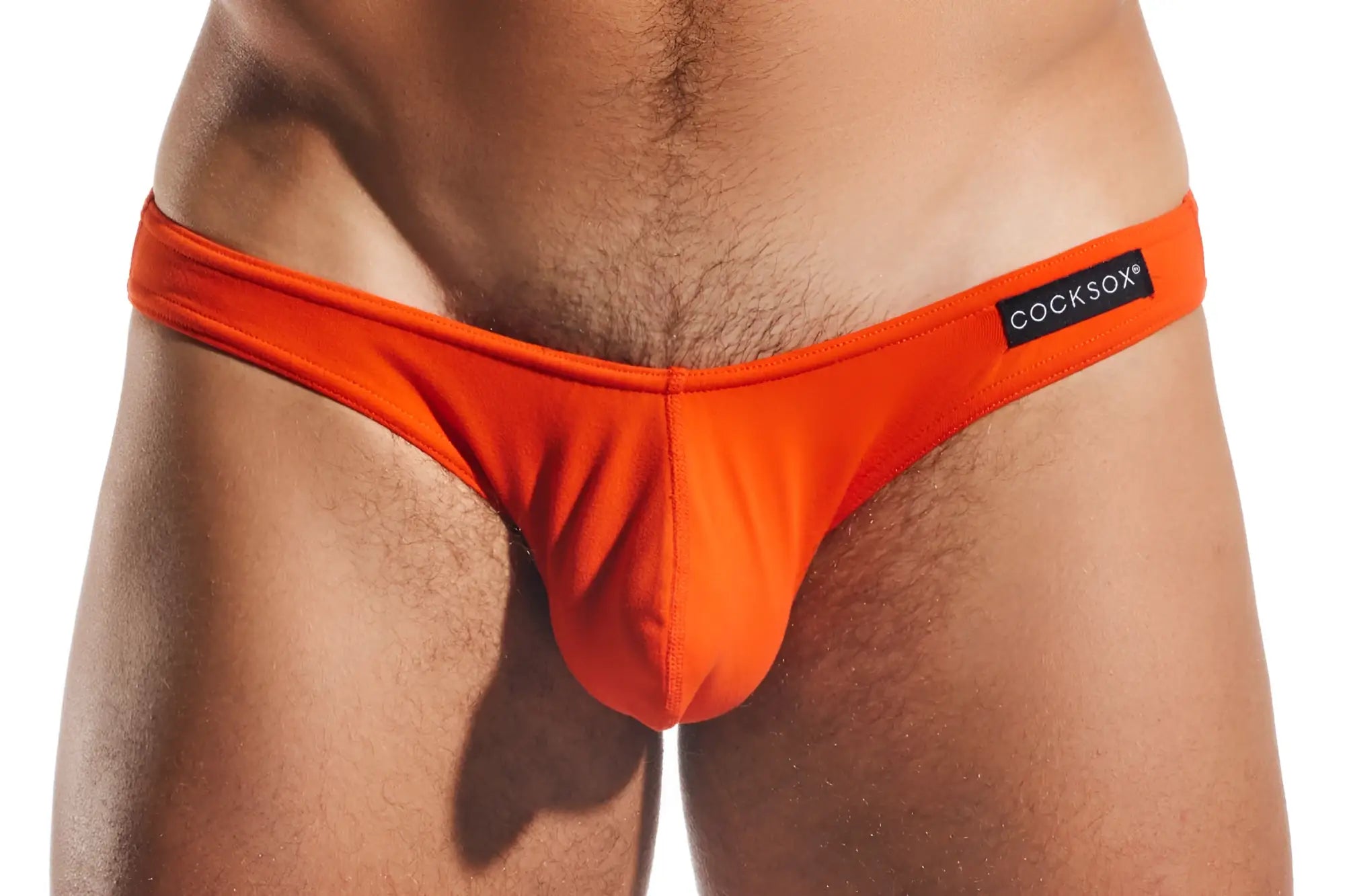Bright orange cocksox cx01 brief thong with black brand label on waistband made from comfortable material