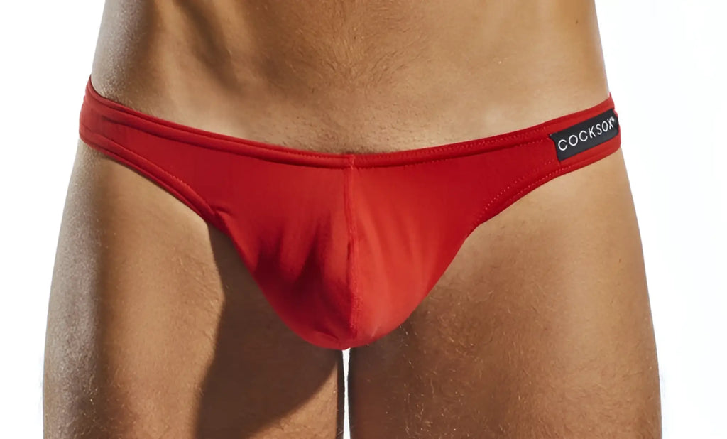 Red Cocksox CX05 thong briefs with smooth form-fitting fabric and a black waistband label visible from the front