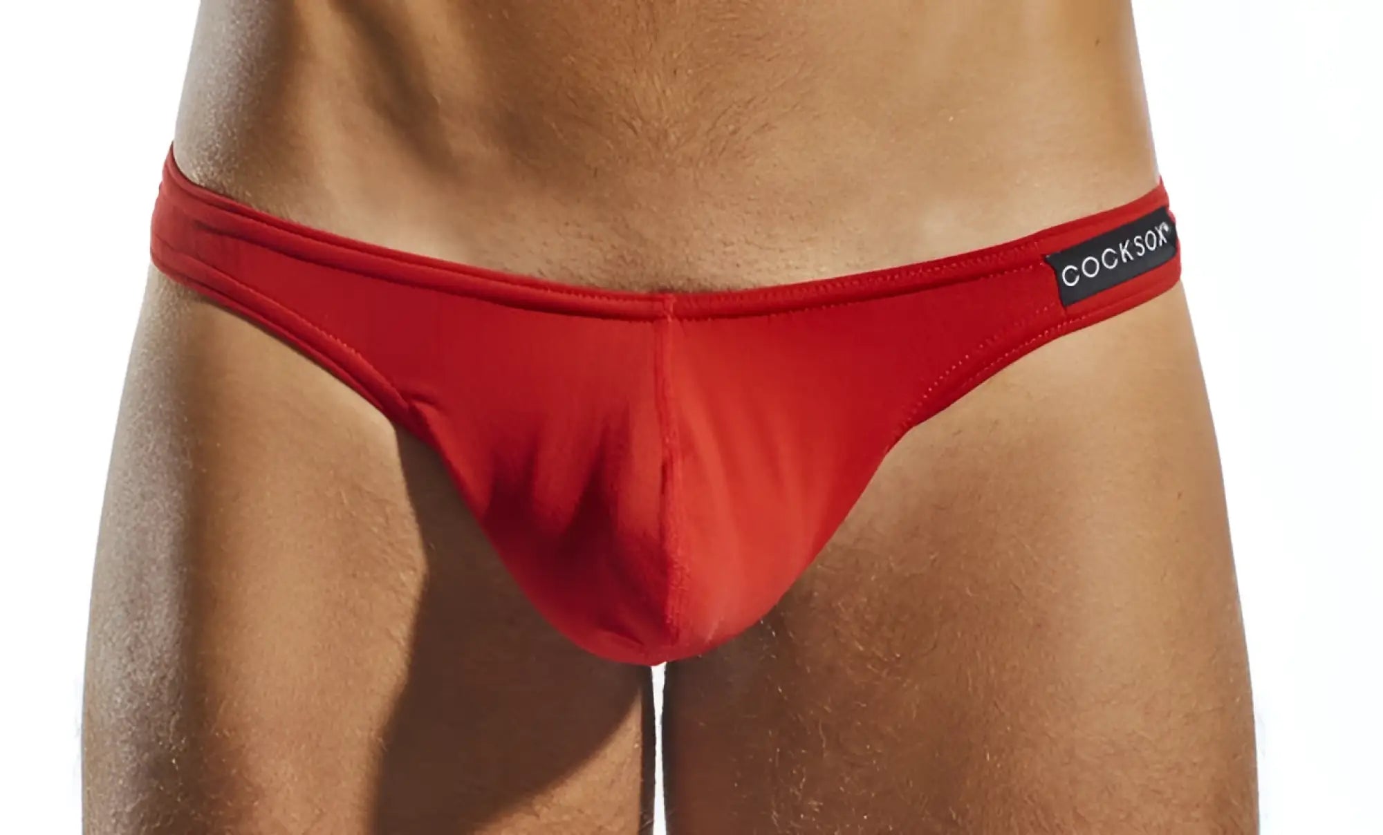 Red Cocksox CX05 thong briefs with smooth form-fitting fabric and a black waistband label visible from the front