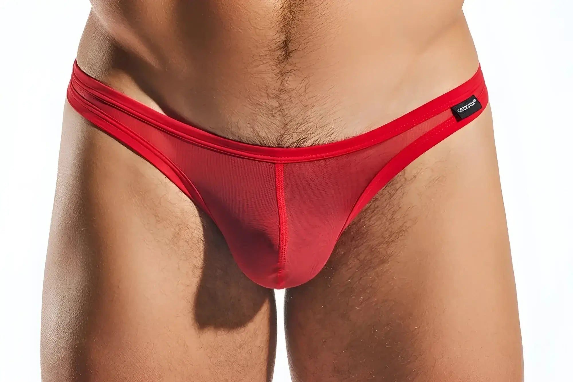 Red mesh thong with solid red waistband and black Cocksox brand tag showing the front side of the CX05ME model