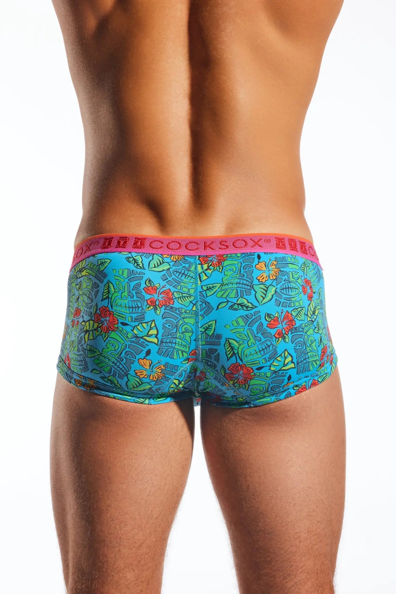 Bright turquoise tropical-patterned men’s briefs with a pink waistband featuring the cocksox brand name
